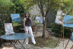 Gwenaëlle Cochevelou pendant son exposition pose devant ses toiles